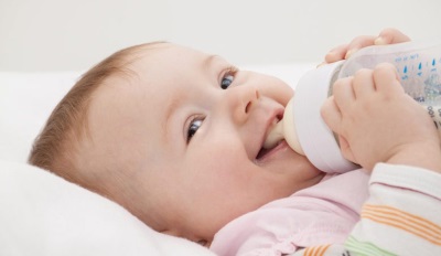 Ребенок ест смесь на основе козьего молока
